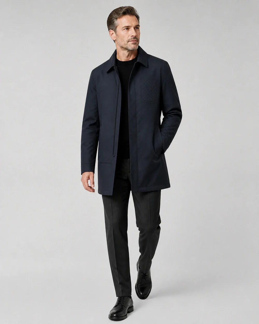 Dark blue mid-length coat for men, walking studio view.