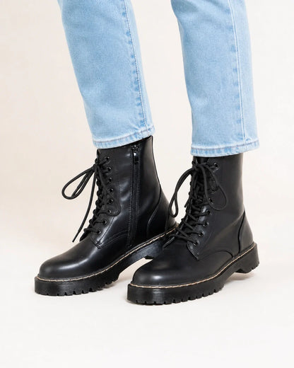 Black lace-up winter ankle boots for women, worn close-up