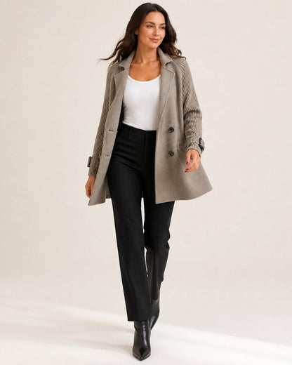 Taupe mid-length coat with knit sleeves worn in movement.